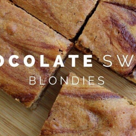 Chocolate Swirl Blondies cortado en cuadrados en una tabla de cortar.