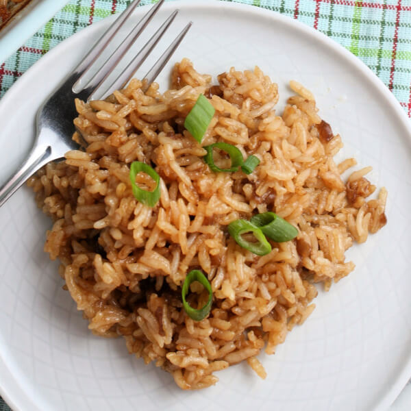 barra de arroz con mantequilla en un plato blanco adornado con cebollino