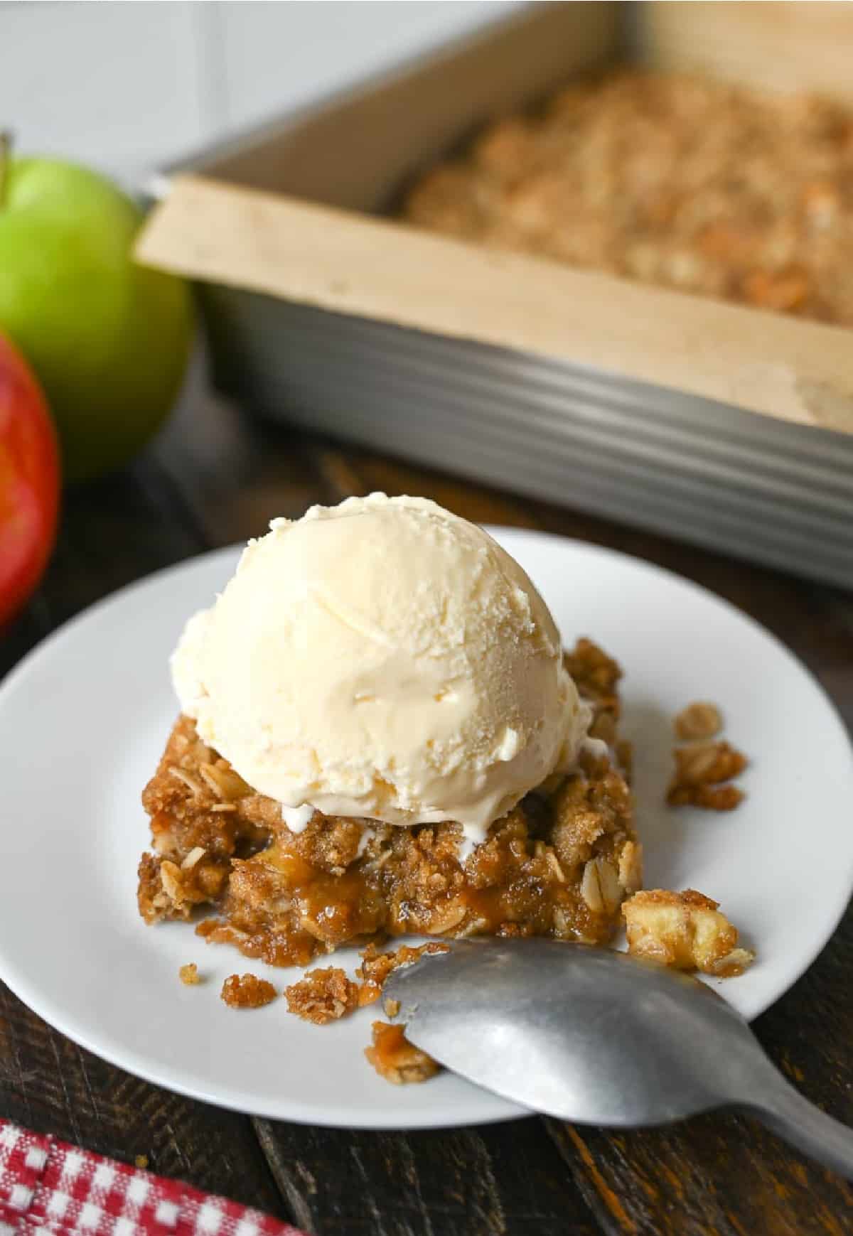 Una ración de crumble de manzana con una bola de helado encima.