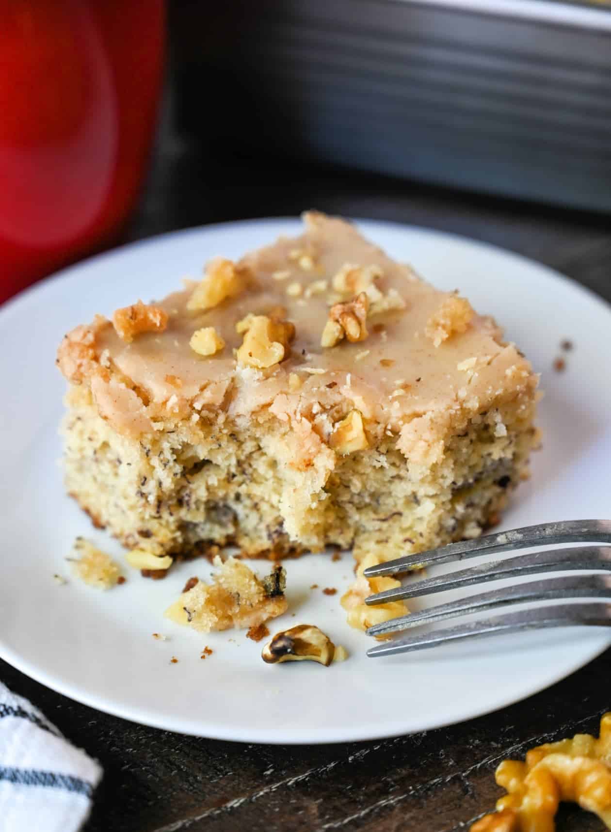 Un trozo de pastel de plátano en un plato con un tenedor