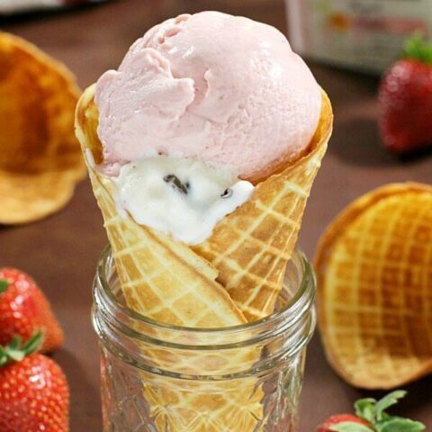 Conos de gofres caseros en un frasco con fresas frescas.