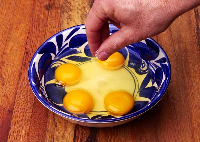 Cuatro huevos rotos en un bol