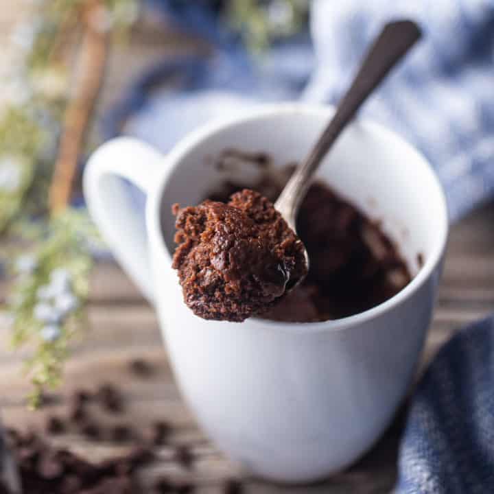 Mug cake de chocolate servido en una taza de cerámica blanca.
