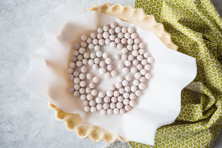 Pastel ciego con pergamino y pesas de cerámica para pastel.