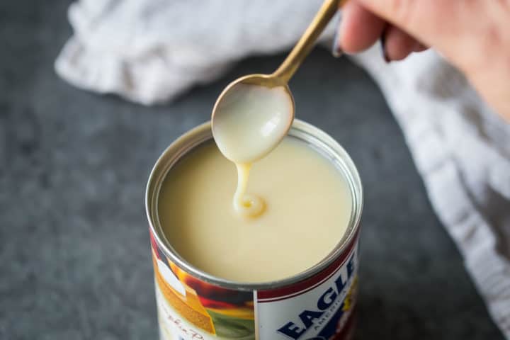 Lata de leche condensada sobre fondo gris oscuro.