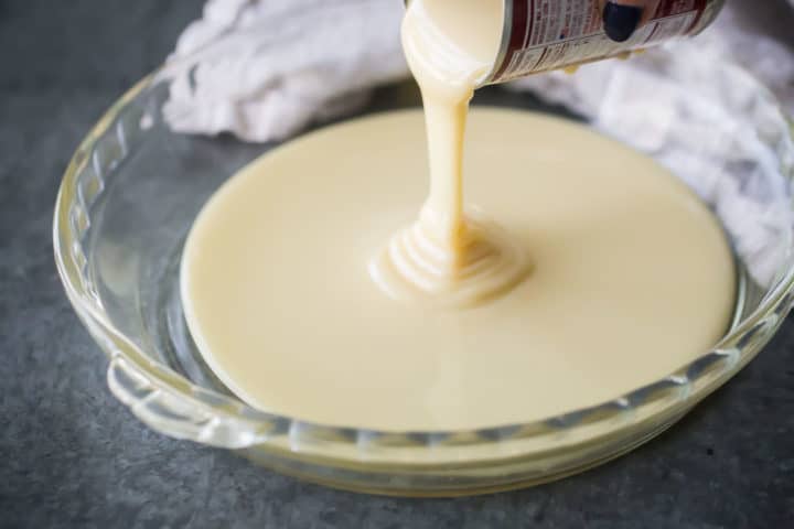 Vierta la leche condensada en una fuente de vidrio para hornear.