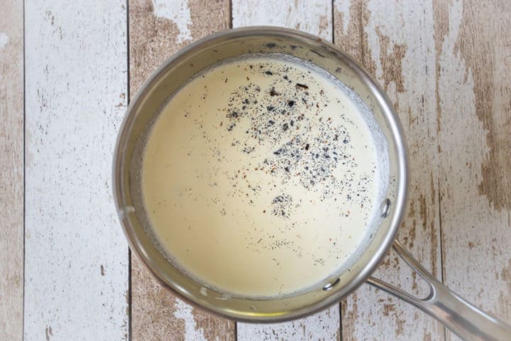 Crema agria en una sartén con la adición de semillas de vainilla.