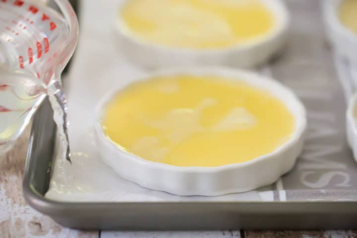 Verter agua caliente alrededor de la crema brulée.
