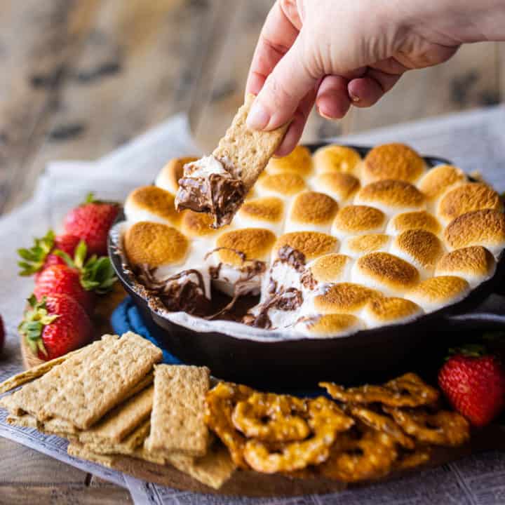 Sumerja una galleta Graham en una salsa de s'mores cocinada en una sartén.