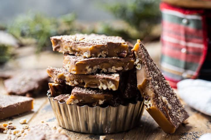 Dulces caseros apilados en una placa de metal con cintas y vegetación en el fondo.