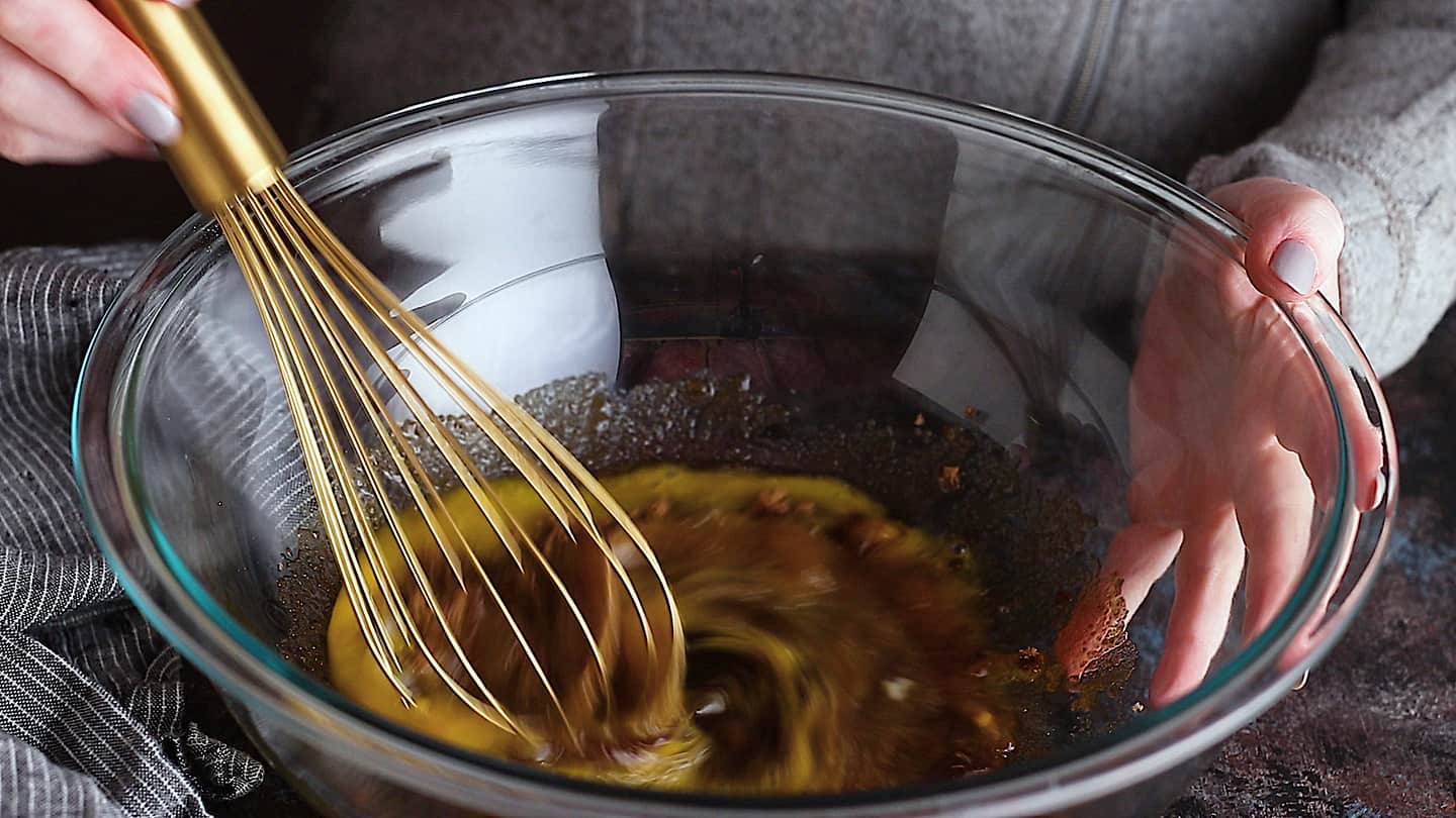 Batir los huevos y el azúcar moreno para hacer el pastel de nueces con chocolate.