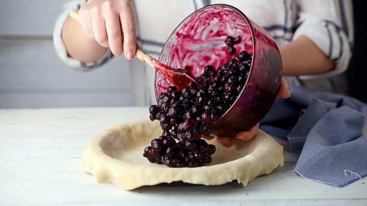 Transfiera el relleno de pastel de arándanos a una base de pastel sin hornear.