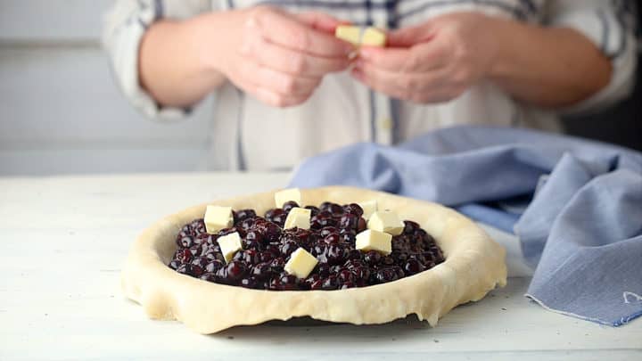 Salpicando el pastel de arándanos con mantequilla.