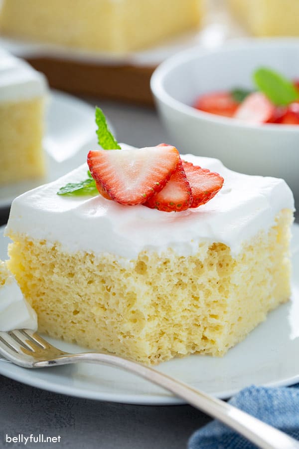 rebanada de pastel de tres leches en plato blanco con tenedor