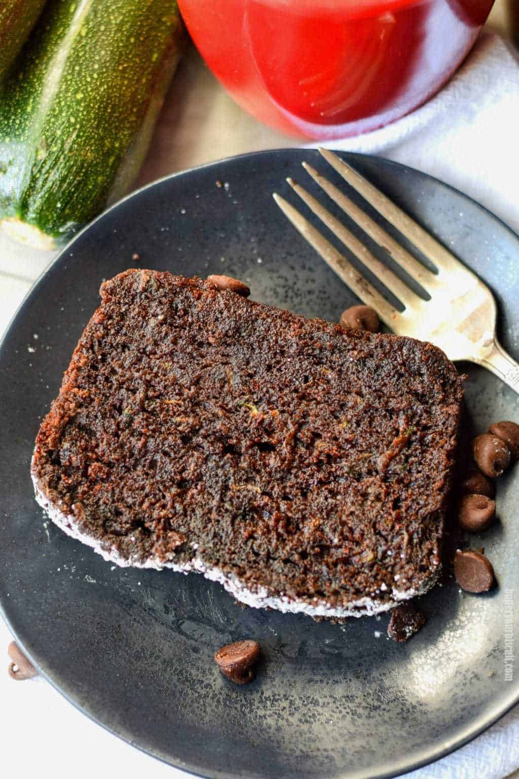 pan de calabacín de chocolate en un plato negro con un tenedor