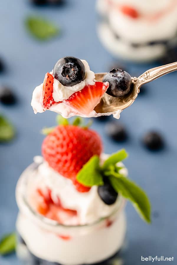 arándanos frescos y fresas en rodajas con mousse de tarta de queso en cuchara