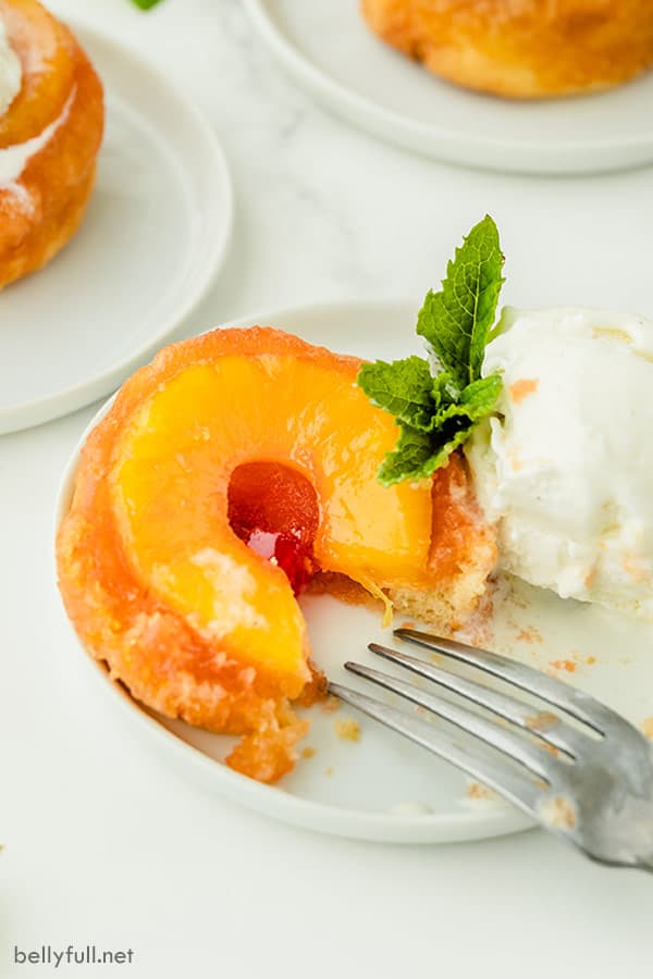 Postre al revés con cáscaras de piña individuales a las que les falta una pieza en un plato blanco con helado y hojas de menta fresca