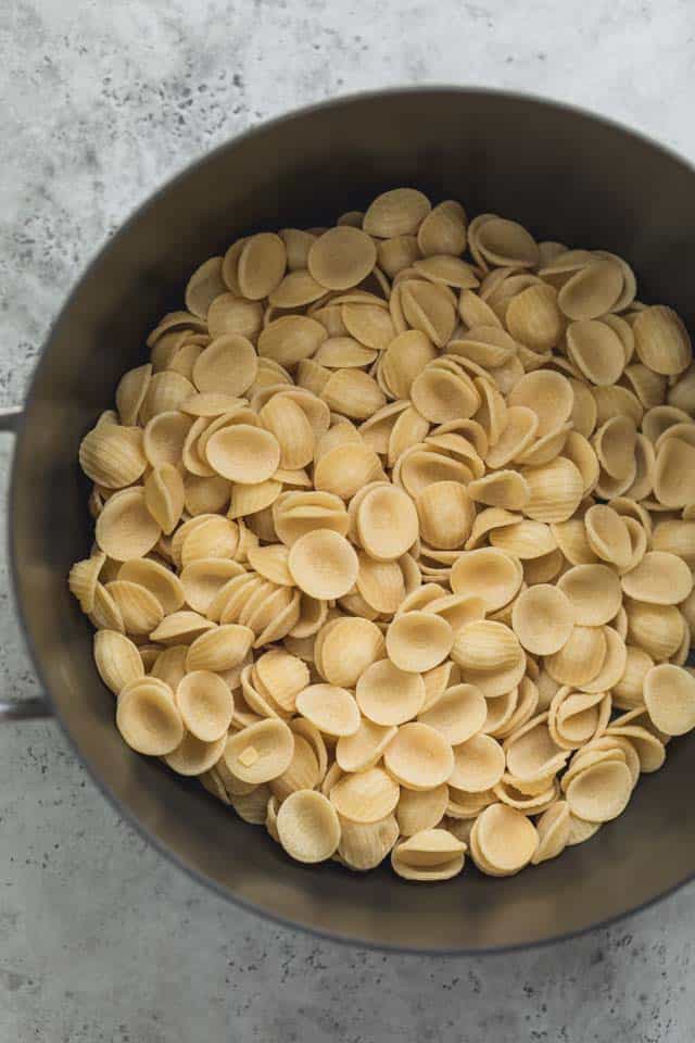 Orecchiette crudo en una gran olla negra