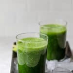Receta de batido de col Detox en dos vasos en una bandeja