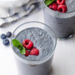 Batido de plátano y arándanos cubierto con frambuesas y menta