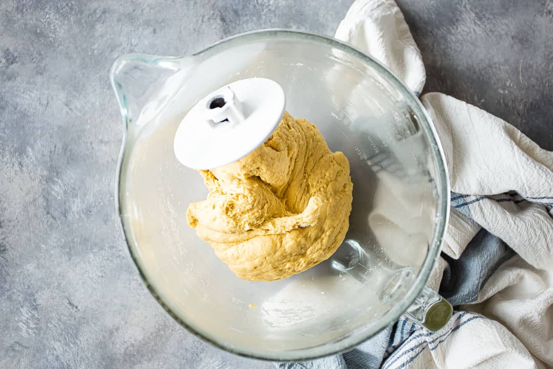 Bollos hawaianos en un bol con un gancho para masa.