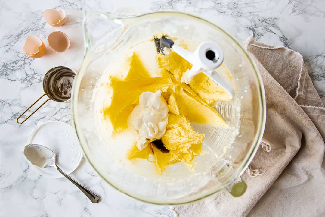 Agregar crema agria a la masa de pastel de chocolate.