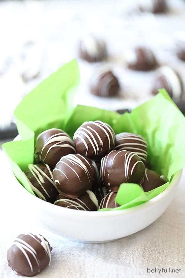 Trufas Oreo en un recipiente blanco con papel de seda verde
