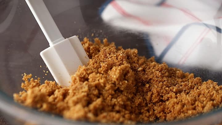 Mezcle la corteza de galleta graham en un recipiente de vidrio con una espátula de silicona.